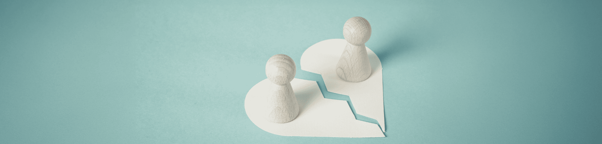 Illustration of two pawn figures on a broken heart representing divorce and family law issues