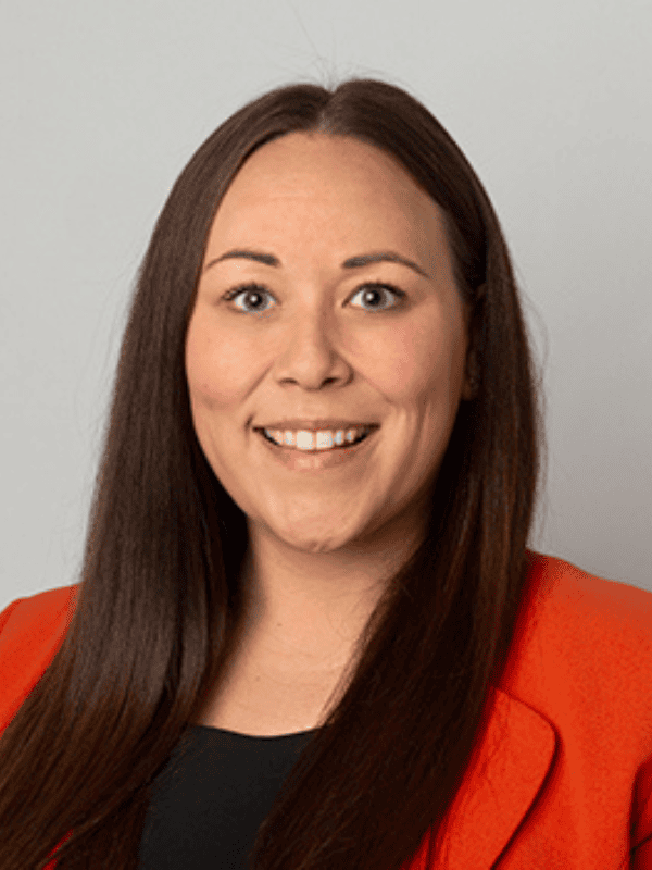 Smiling female solicitor wearing an orange blazer, representing Ellis-Fermor & Negus, a solicitors' firm in the East Midlands.