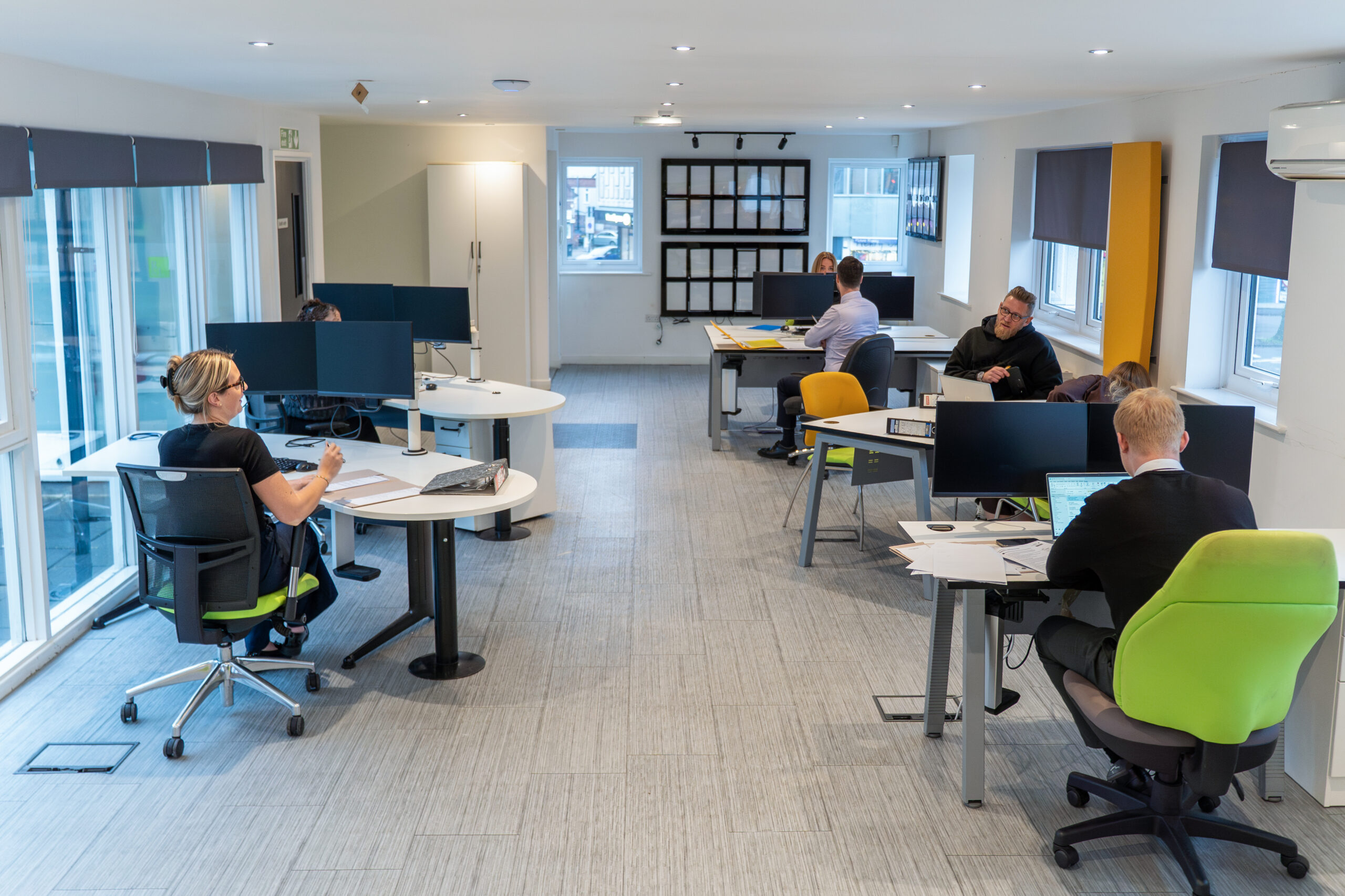 Interior view of the Ellis-Fermor & Negus solicitors office with staff working at desks and computers in a contemporary setting.
