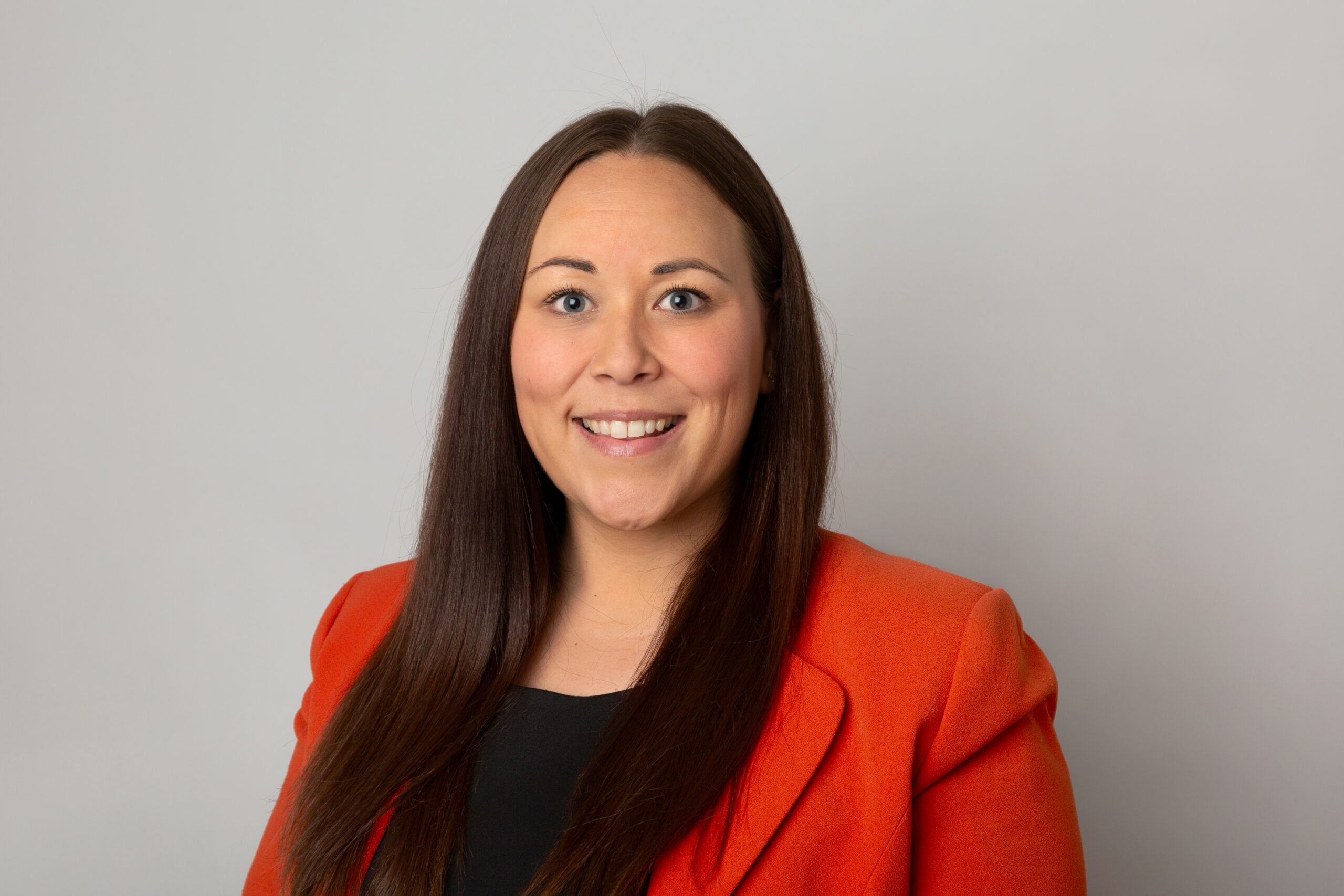 Smiling solicitor in an orange blazer, representing Ellis-Fermor & Negus, offering legal advice in the East Midlands.