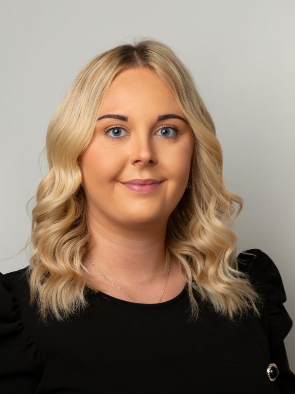 Headshot of a female solicitor with blonde curly hair, wearing a black top, representing Ellis-Fermor & Negus solicitors in the East Midlands