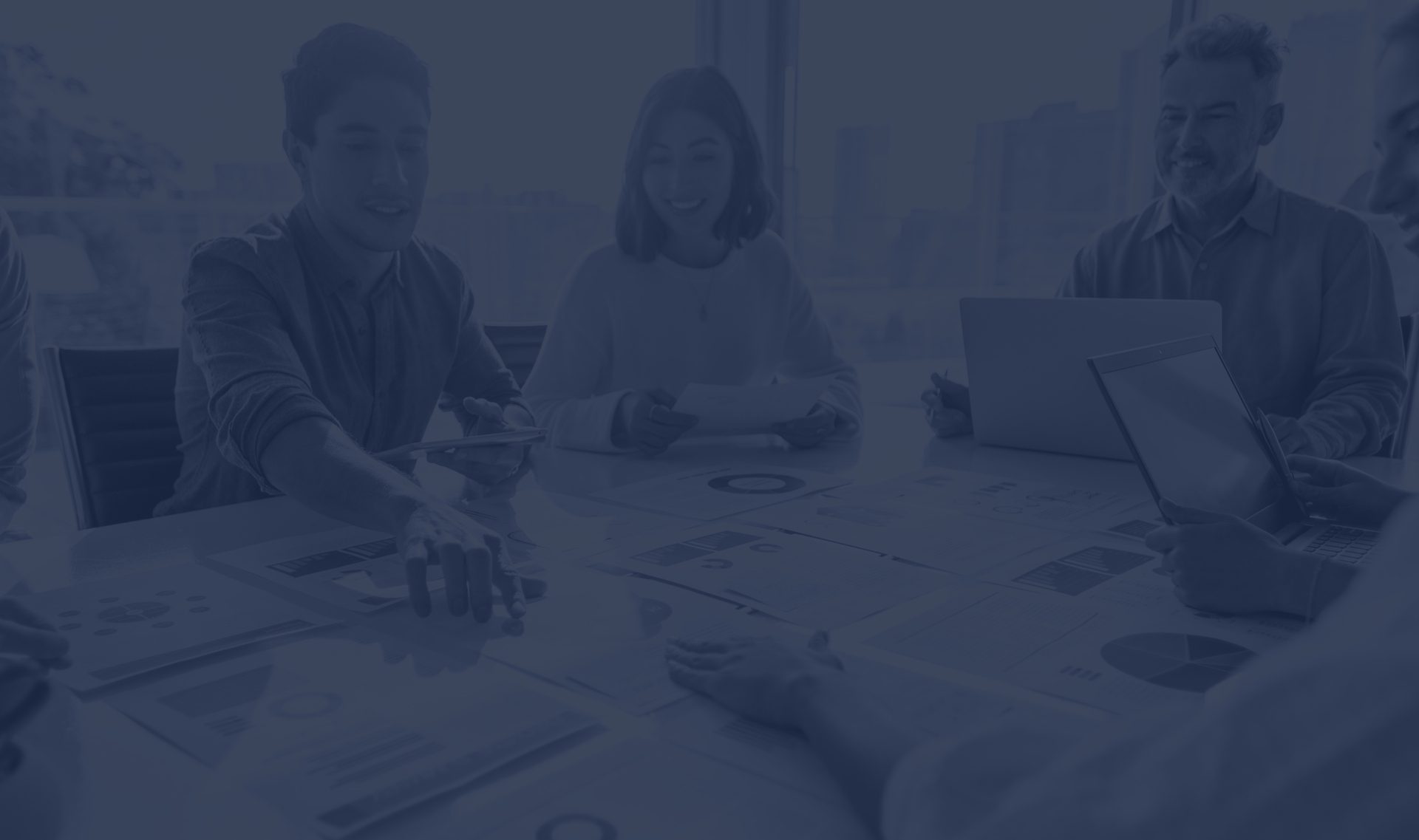 A group of professionals engaged in a collaborative meeting, discussing financial reports and strategies at Ellis-Fermor & Negus solicitors.