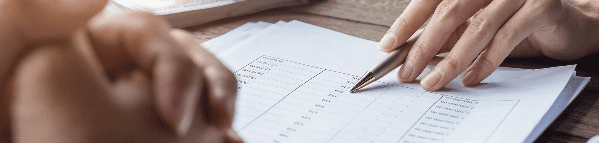 Close-up of hands reviewing legal documents and taking notes in a solicitor's office