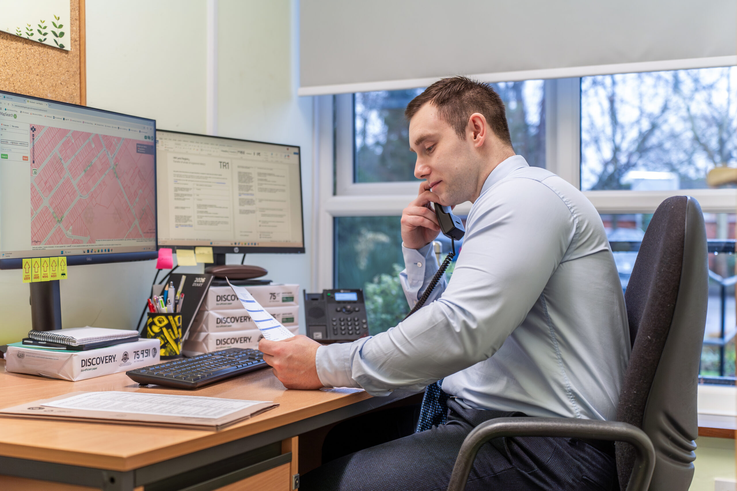 A solicitor at Ellis-Fermor & Negus engaged in a phone call while reviewing documents at his desk in an East Midlands office.