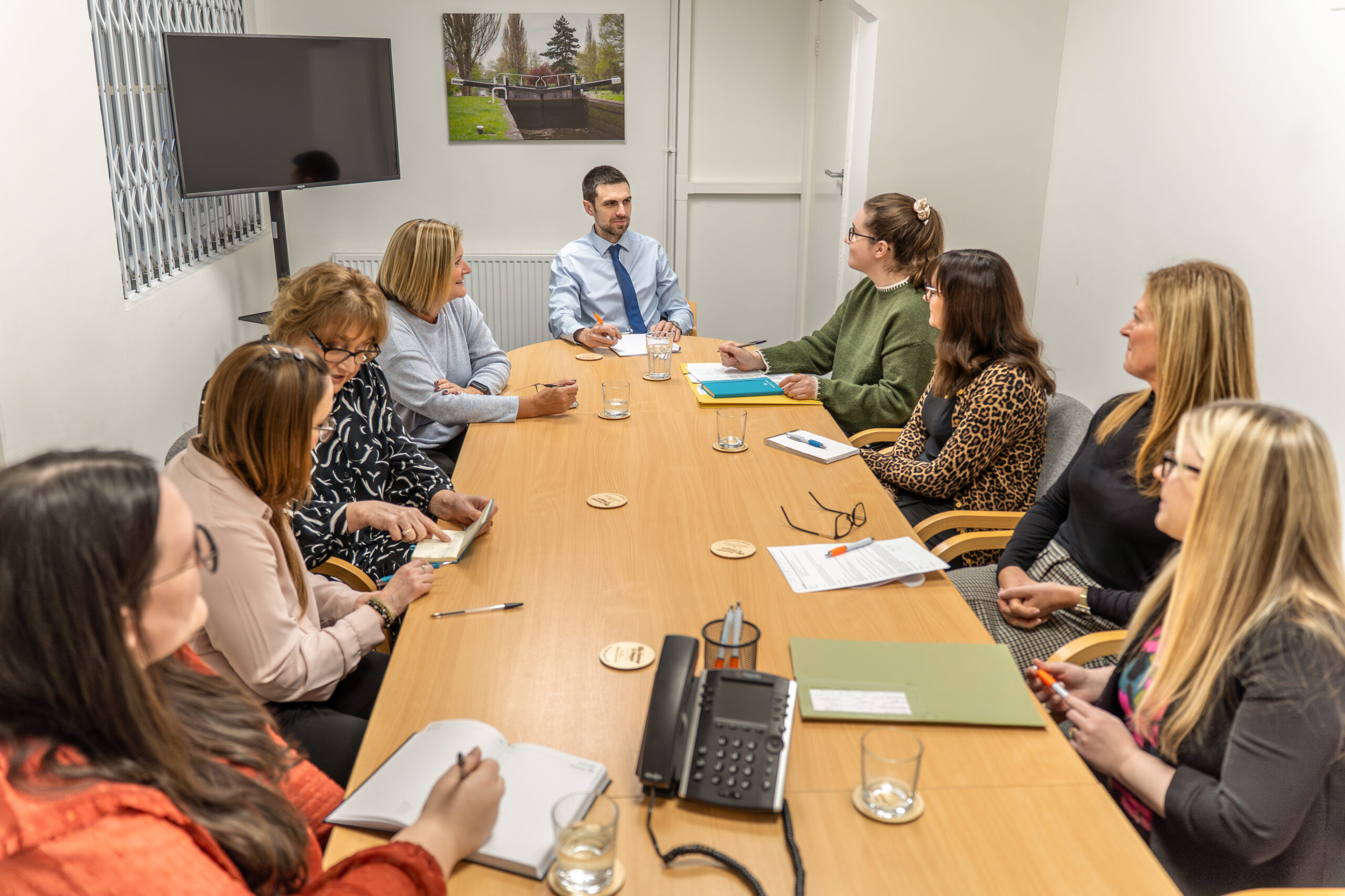 A group of solicitors from Ellis-Fermor & Negus engaged in a meeting discussing legal advice and services in a conference room.