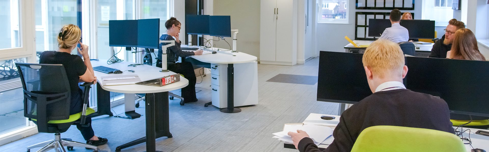 Interior view of Ellis-Fermor & Negus solicitors' office, showcasing a collaborative workspace with legal professionals engaged in various tasks.