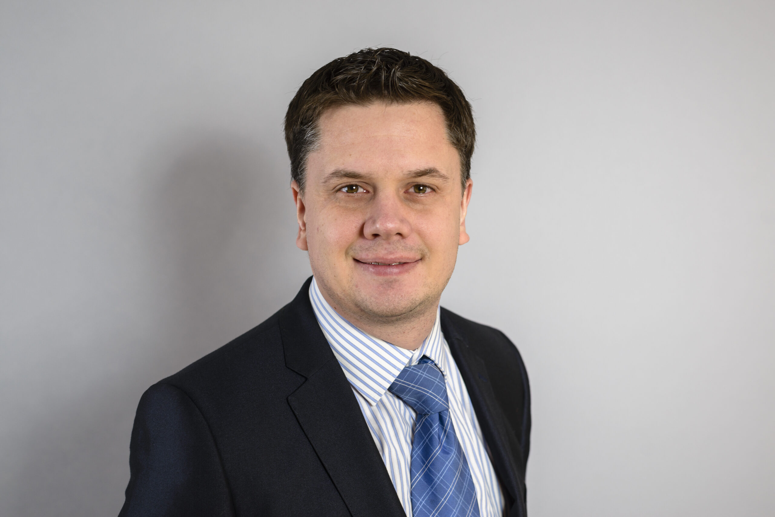 Portrait of a solicitor in a suit with a blue tie, representing legal services at Ellis-Fermor & Negus in the East Midlands.