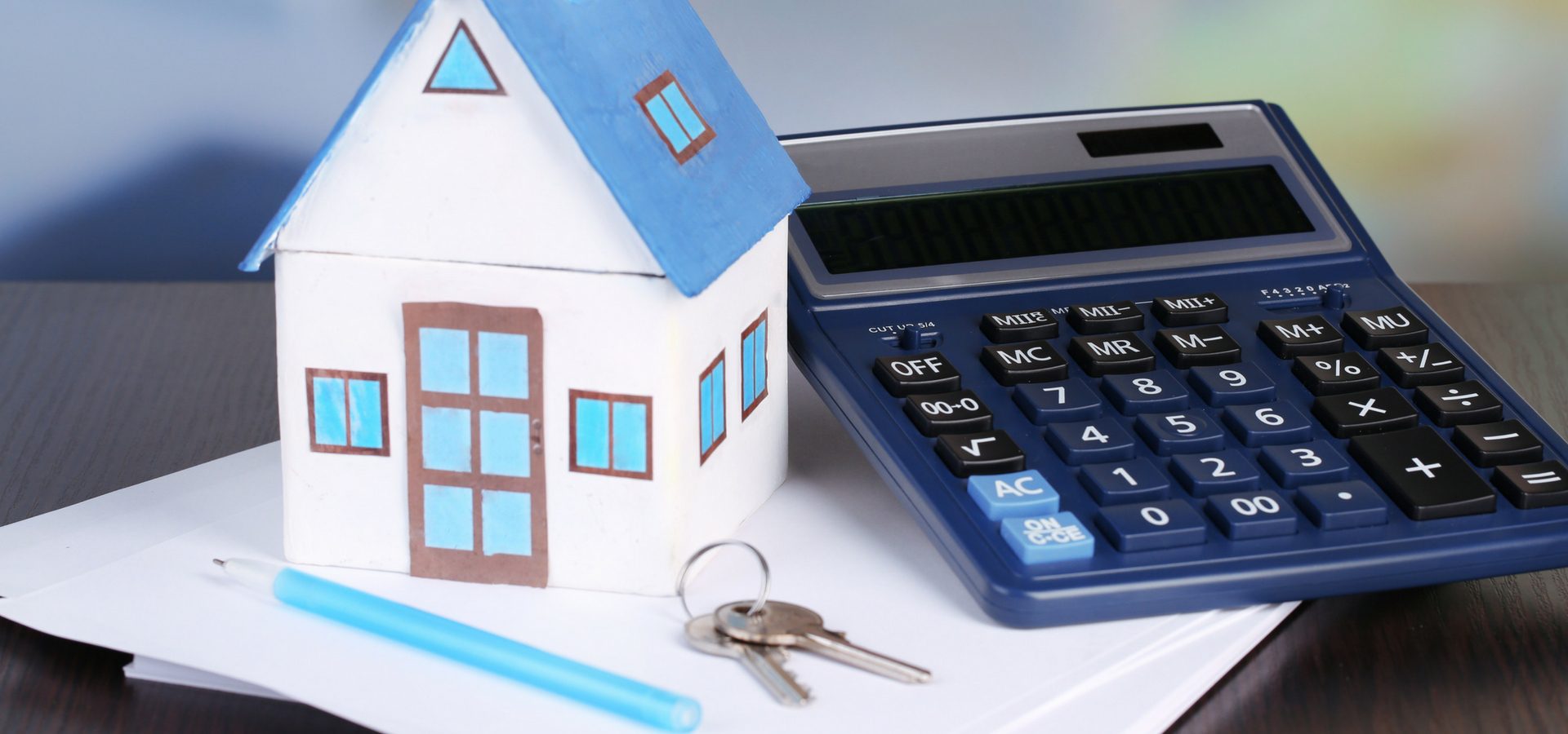Model house, calculator, keys, and paperwork representing residential conveyancing and property law services by Ellis-Fermor & Negus solicitors in East Midlands.